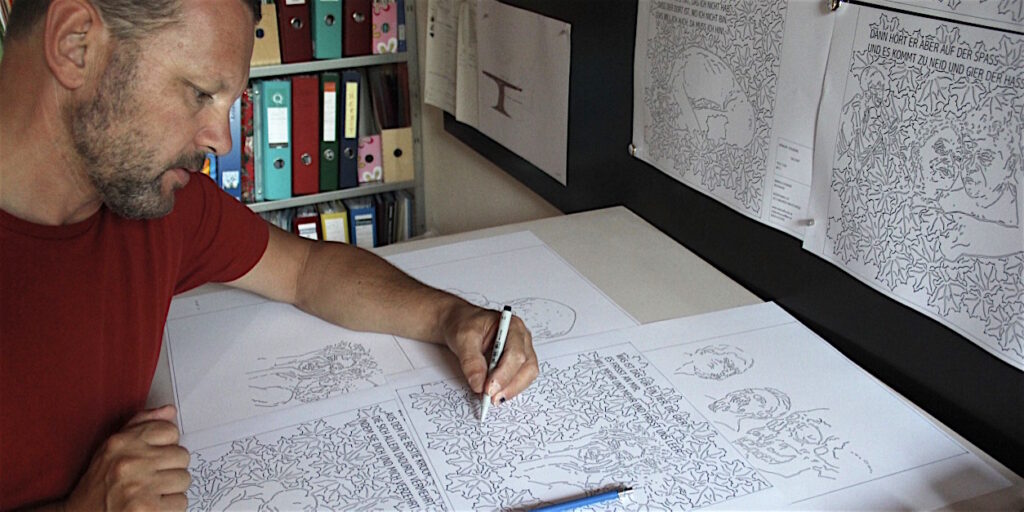 Markus Thurner mit den Entwurfszeichnungen des Totentanzes